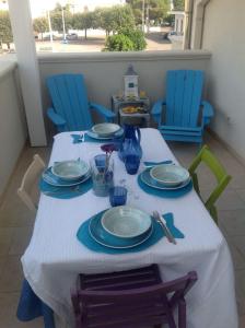 萨维勒特里Maricasa Savelletri的一张桌子上摆放着蓝色的椅子和盘子