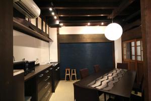 函馆函馆经典旅馆的厨房配有桌子和蓝色的墙壁