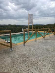 蒙泰斯佩尔托利博尔加斯特拉农家乐的一座带木栅栏旁标志的游泳池