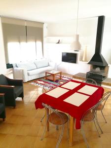 罗萨斯Casa Lorca的客厅配有一张桌子和红色桌布