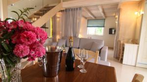 圣斯特凡诺斯Villa Ellie的一张桌子,上面放着一瓶葡萄酒和鲜花