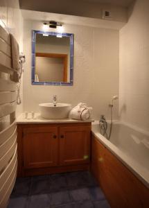 葱仁谷尼日普伦苏公寓式酒店的一间带水槽、浴缸和镜子的浴室