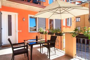 斯特雷萨Apartments La Lombarda Centro Storico Stresa的阳台上配有带雨伞的桌子