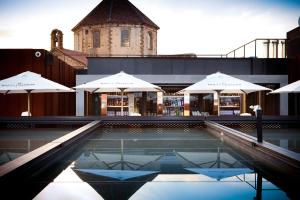 巴塞罗那西班牙兰布拉酒店的大楼前的带遮阳伞的游泳池
