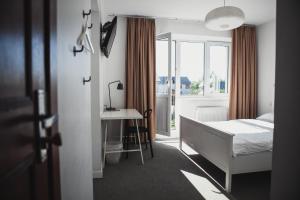 德鲁斯基宁凯萨卡度假酒店的一间卧室配有一张床、一张书桌和一个窗户。