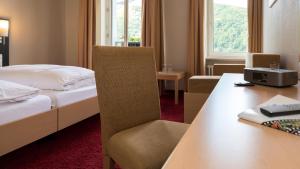 吕德斯海姆拉姆莱茵酒店的配有一张床、一张桌子和一张桌子的酒店客房