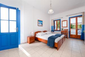 阿达玛斯叶莱妮酒店的一间卧室配有一张床和一个蓝色的门