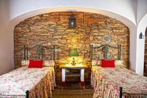 蒙萨拉什Casa Saramago的石墙客房的两张床