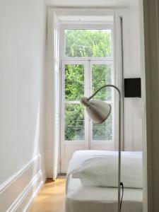 波尔图Porto Republica Riverside的卧室配有一张床,窗户前配有一盏灯