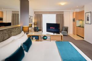 墨尔本Treasury on Collins的酒店客房设有一张大床和一台电视机。