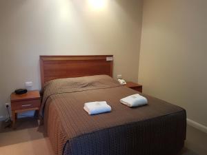 努里乌特帕巴罗莎美酒酒店的一间卧室配有一张床,上面有两条毛巾