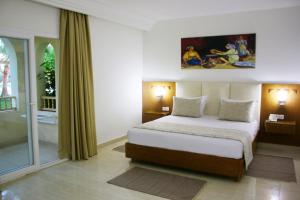 米多恩The Ksar Djerba Charming Hotel & SPA的一间卧室设有一张床和一个大窗户