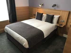 都柏林肯尼迪德鲁姆康德拉住宿加早餐旅馆的一间卧室配有一张大床和木制床头板