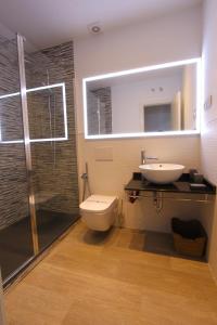 马德里阿尔玛套房公寓的浴室配有卫生间、盥洗盆和淋浴。