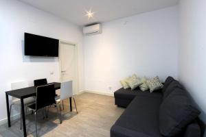 马德里阿尔玛套房公寓的客厅配有黑色沙发和桌子