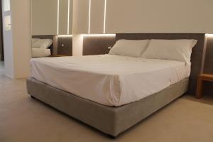 加利波利Seven Suite的卧室内的一张带白色床单和枕头的床