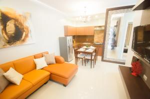 达沃市NF套房公寓的一间带橙色沙发的客厅和一间厨房