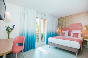 尼斯尼斯长廊公寓式酒店的卧室配有一张床和一张桌子及椅子
