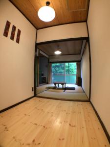 秋留野大津大自然公园旅馆的一间空房间,铺有木地板,设有窗户