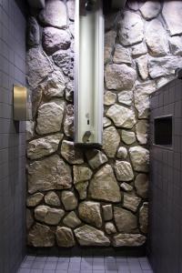 赫尔辛基欧洲旅馆的浴室设有石墙,配有淋浴