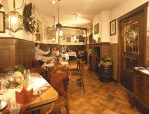 贝尔恩卡斯特尔-库斯Märchenhotel的一间餐厅,人们坐在房间里桌子旁