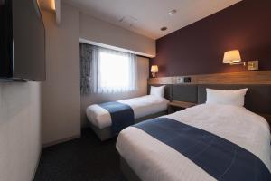 津市津西庭院豪华酒店的酒店客房设有两张床和窗户。