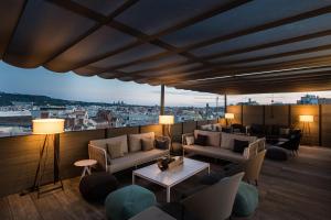 巴塞罗那加泰罗尼亚兰布拉大道酒店的阳台配有沙发,享有城市景观