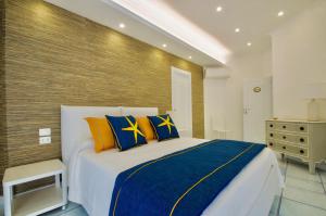 马奥莱B&B Maiori Luxury的一间卧室配有一张带蓝色和黄色枕头的大床