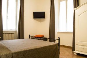 罗马波波罗多姆斯广场住宿加早餐旅馆的卧室配有一张床,墙上配有电视。