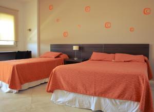 里奥夸尔托拉波萨达德尔维赫罗宾馆的一间卧室设有两张带橙色床单的床和窗户。