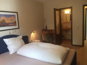 舍瑙ICC广场豪弗酒店和会议中心的一间卧室配有一张带白色床单和镜子的床