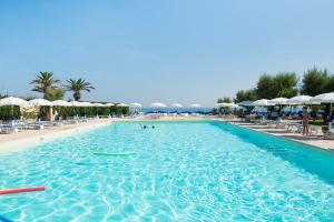 托雷坎内德尔莱万特酒店的度假村的游泳池,带遮阳伞和海滩