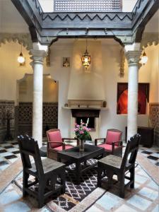 丹吉尔阿鲁斯卡梅尔摩洛哥传统庭院旅馆的大堂设有桌椅和壁炉。