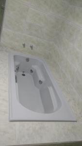 Telêmaco BorbaHotel Mariluz的瓷砖浴室设有白色浴缸。