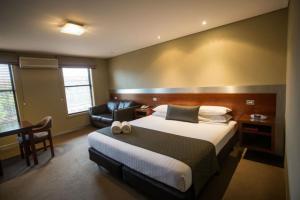 仙女港Seacombe House Motor Inn Port Fairy的配有一张床和一张书桌的酒店客房