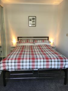 因弗内斯32a railside的一间卧室配有一张带红白色拼盘的床铺。
