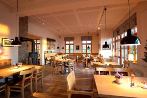 巴特哈尔茨堡Plumbohms Aussichtsreich Gast- und Logierhaus的餐厅设有木桌、椅子和窗户。