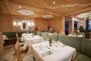 达米尔斯瓦利塞尔斯托普酒店的餐厅设有2张带白色桌布的桌子