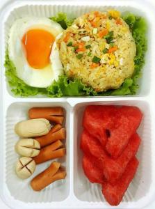 曼谷城镇旅馆的塑料午餐盒,包括米饭、鸡蛋和蔬菜