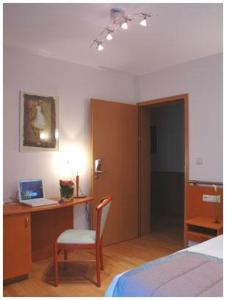 沙勒罗瓦南沙勒罗瓦机场酒店的一间卧室配有一张床和一张带笔记本电脑的书桌