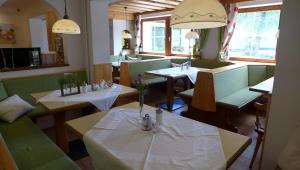 KrakauebeneGasthof Schallerwirt的一间在房间内配有桌椅的餐厅