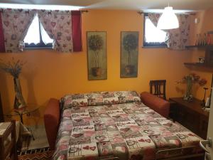 奥斯塔La Tavernetta的一间卧室设有一张床和两个窗户。