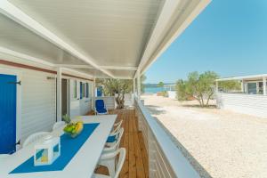 斯维蒂佩塔Mobile home Laguna的一个带蓝色桌椅的门廊和海滩
