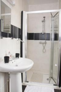 布里德灵顿Pretoria Guest House的一间带水槽和淋浴的浴室
