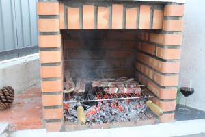 PereiroPro Touristic Casa Montejunto的砖砌壁炉,里面装满了食物和葡萄酒
