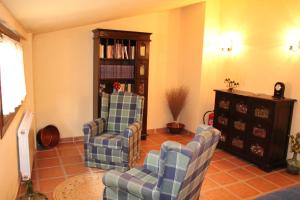 Aguilar del Río AlhamaCasa Rural Celtia的客厅配有两把椅子和书架