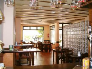 坎巴多斯奥拉格酒店的一间带木桌椅的餐厅和一间用餐室