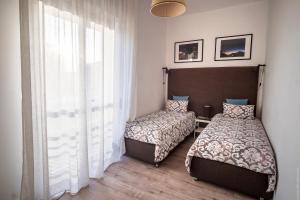 锡拉库扎Domus Claudia - Casa Vacanze的一间卧室设有两张床和窗户。