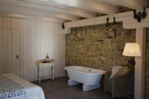 德尔吉切萨菲之家旅馆的一间带浴缸的卧室,位于一间设有床铺的房间