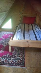 乌斯马Dižāpas的地板上铺着地毯的房间的一张床位